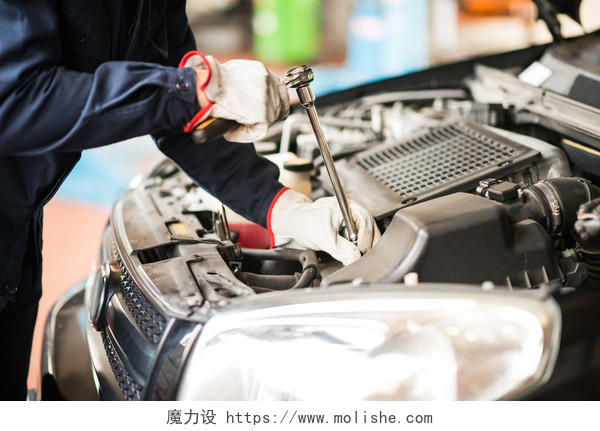 汽车修理工在汽车上在他的车库里工作的细节合作